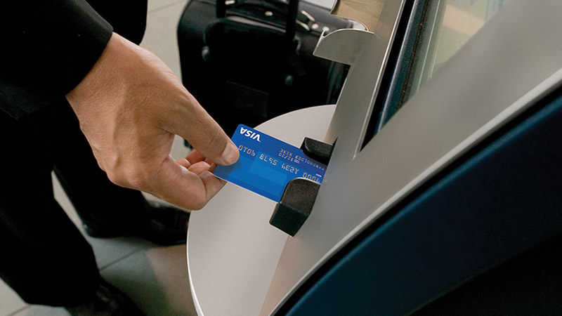 Person using an ATM overseas with their Visa EMV chip card